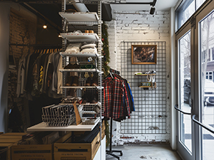 An image of a clothing rack and black wire grid unit in a compact store space
